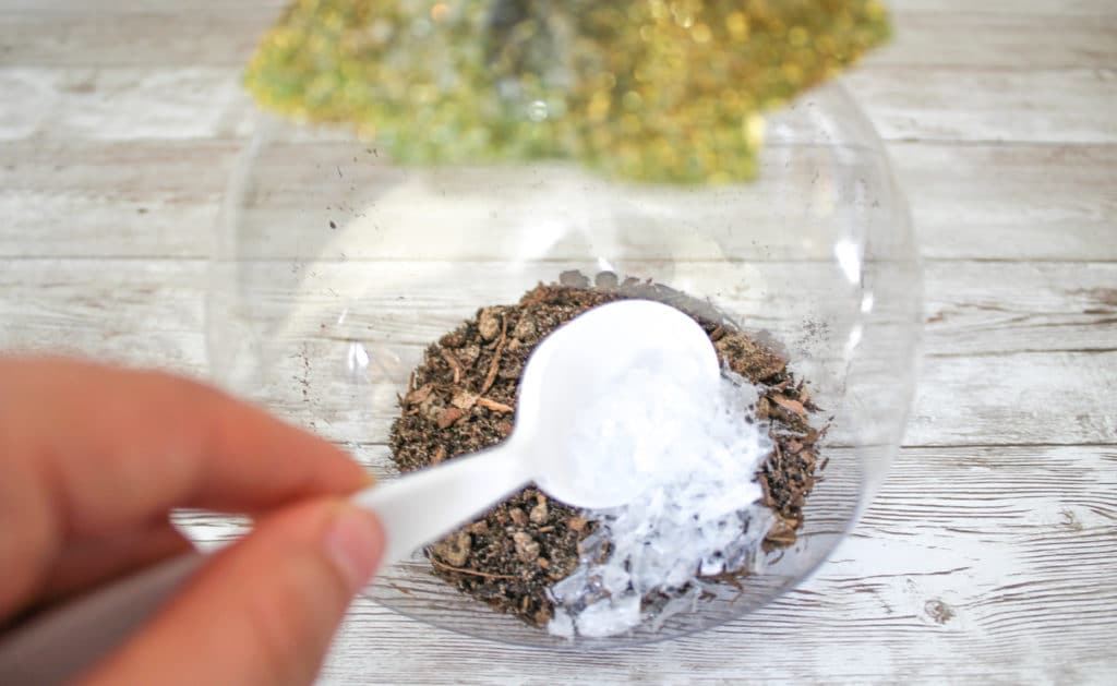 Filling the Christmas tree ornament with succulent soil and artificial snow