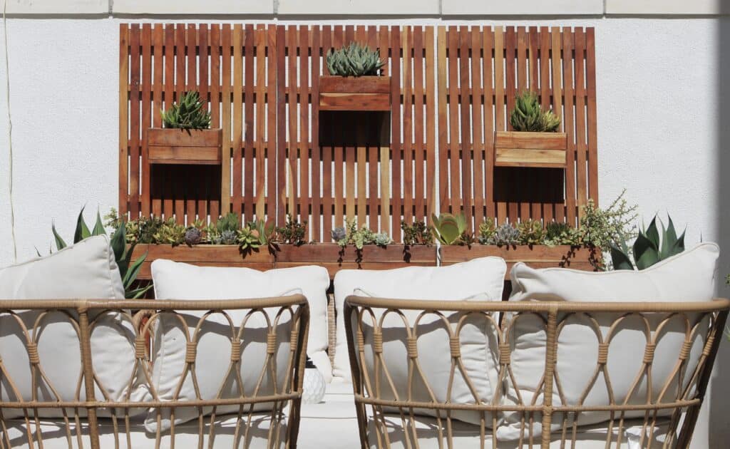 Side yard patio featuring white patio furniture and wooden wall planter with succulent planter boxes.
