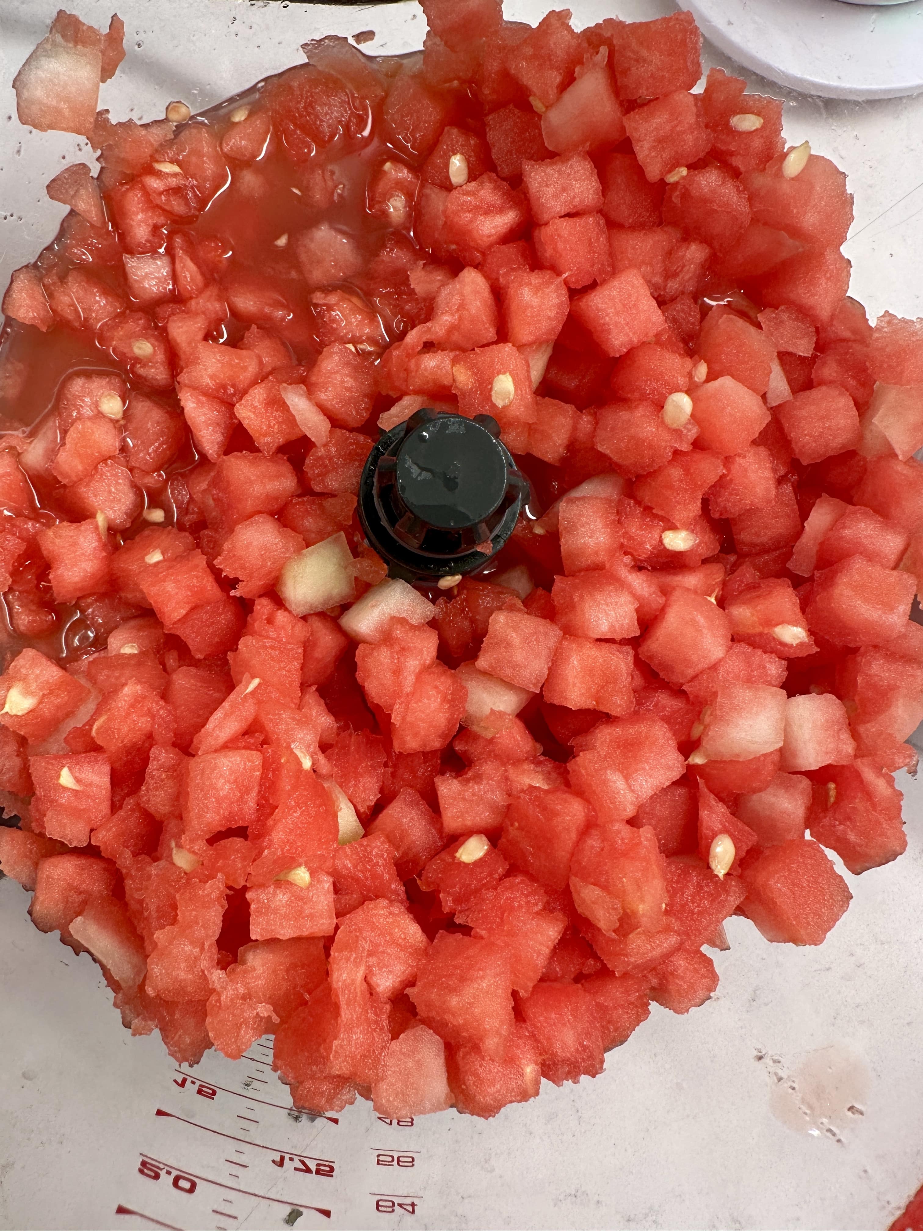 Chopped watermelon pieces inside a food processor.
