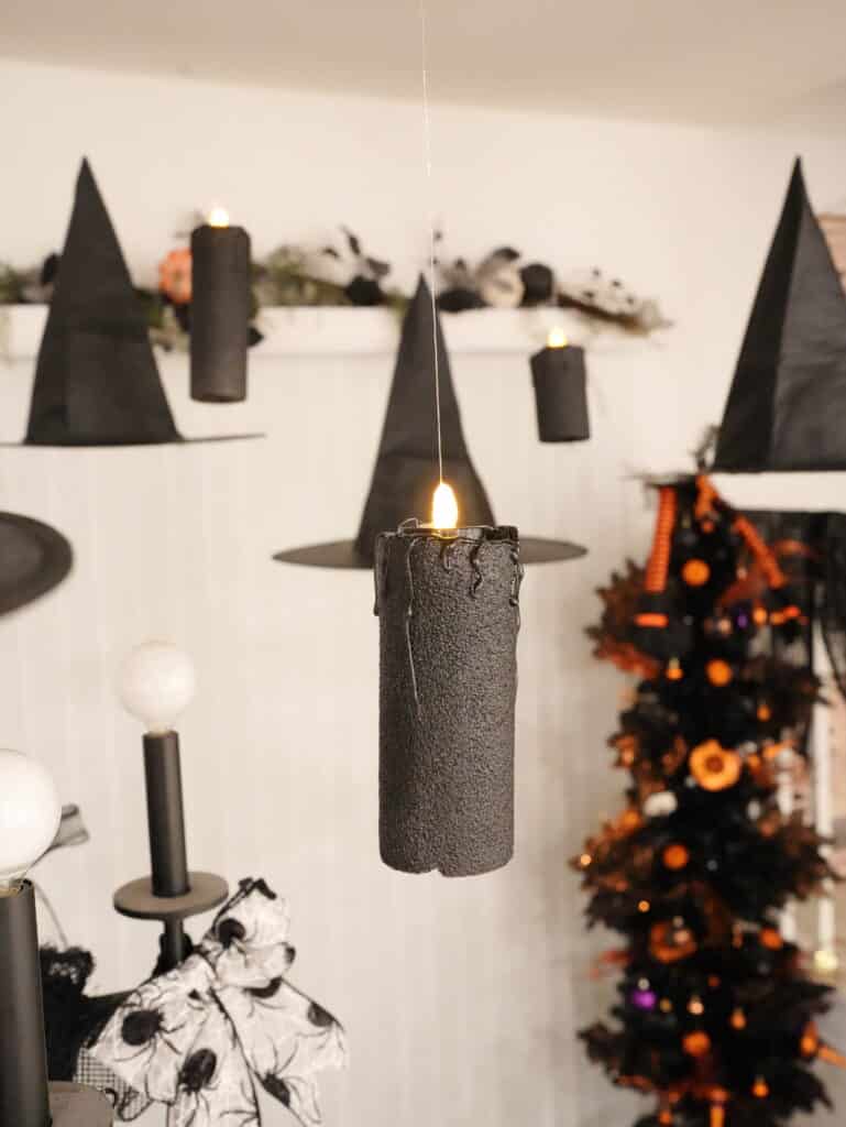 Halloween candles and witch hats floating from the ceiling