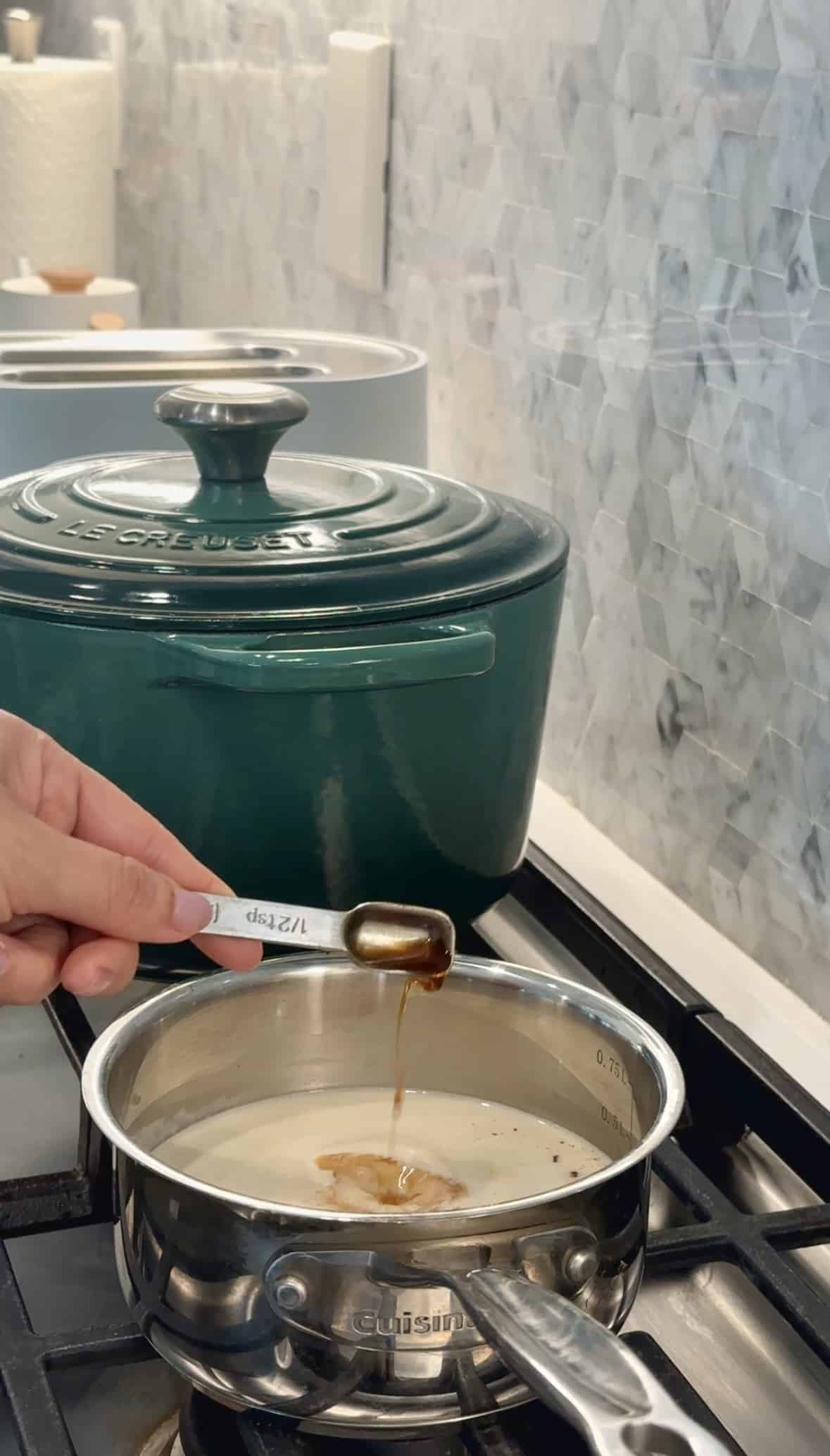Vanilla extract being poured into pot on the stove