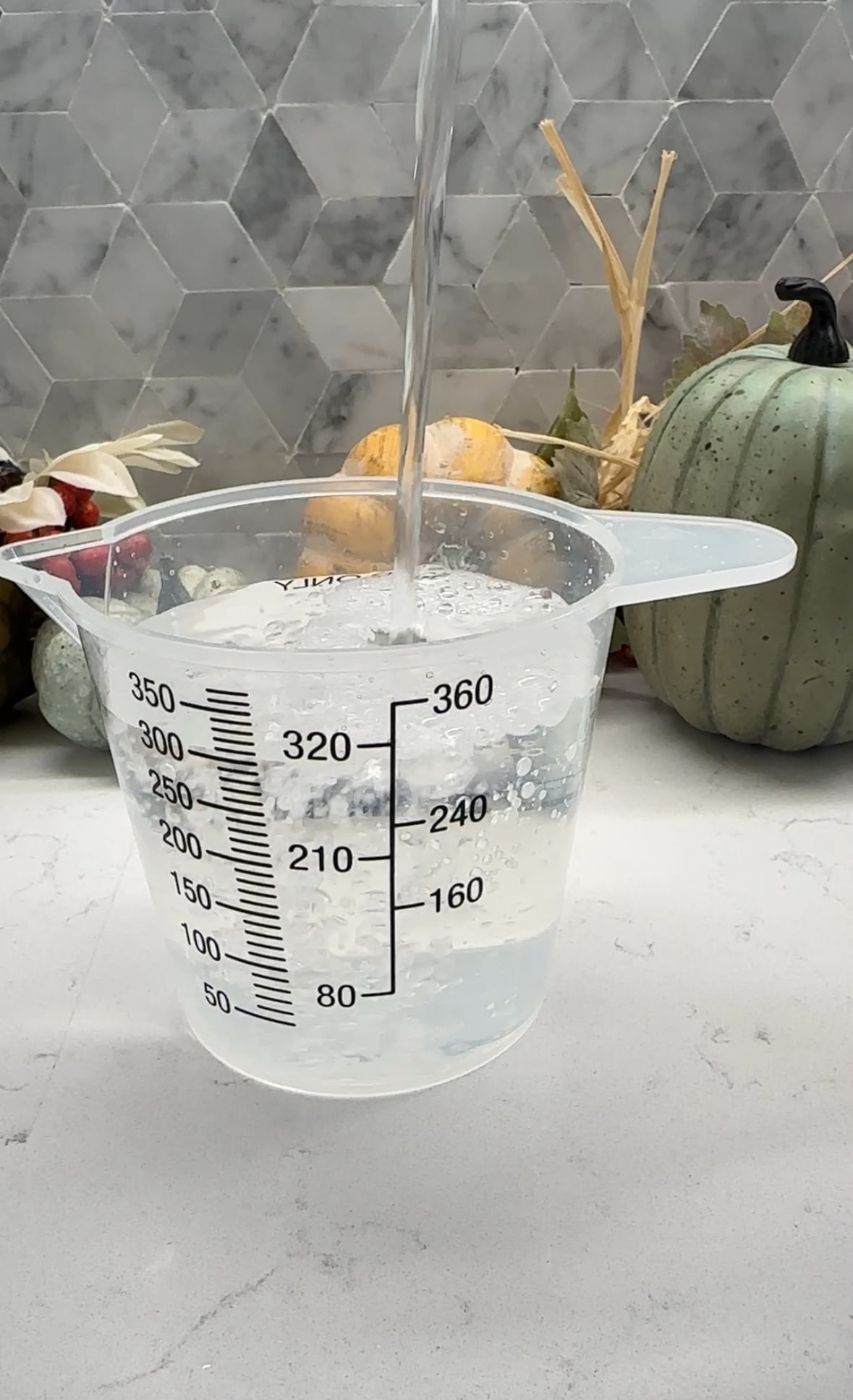 Plastic measuring cup with water and distilled vinegar