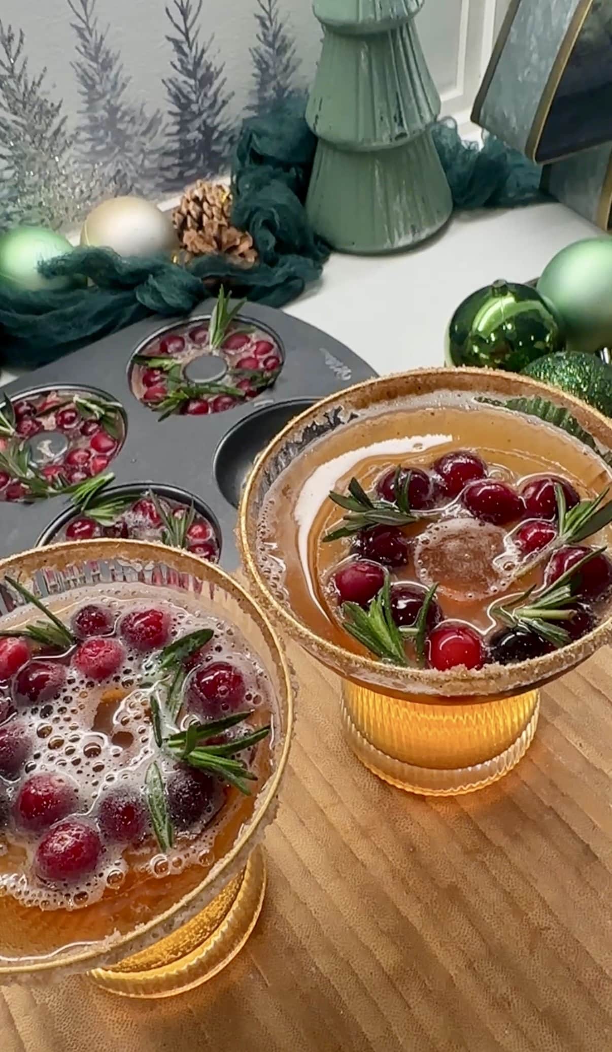 Cockatil glasses filled with apple cider and cranberry iced wreaths